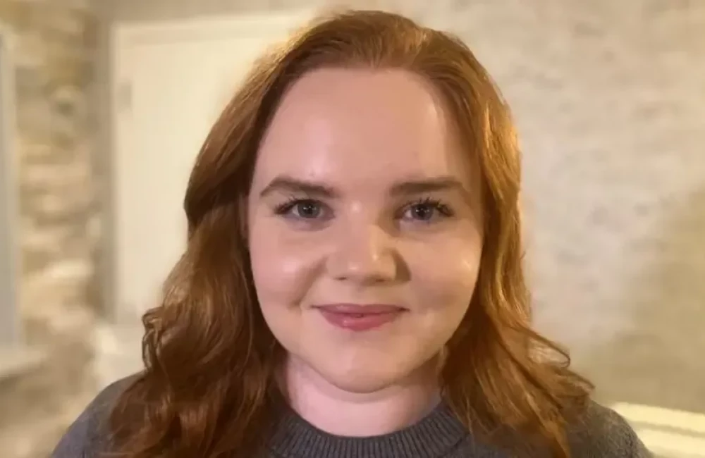 A woman with red hair smiling at the camera