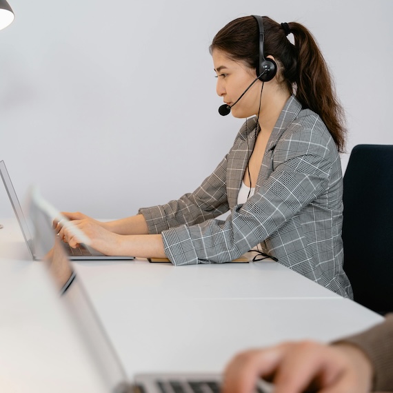 A woman talks on the phone using a headset