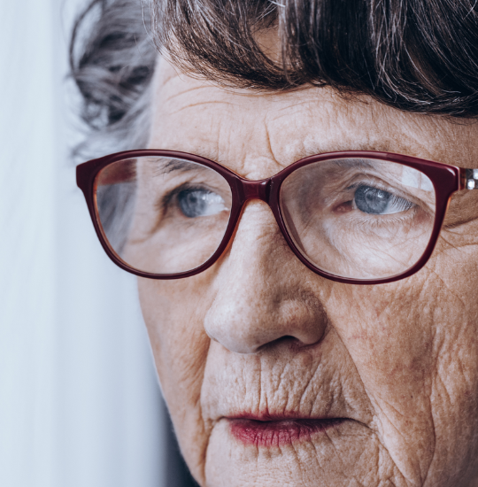 Older woman with glasses looking off to the left